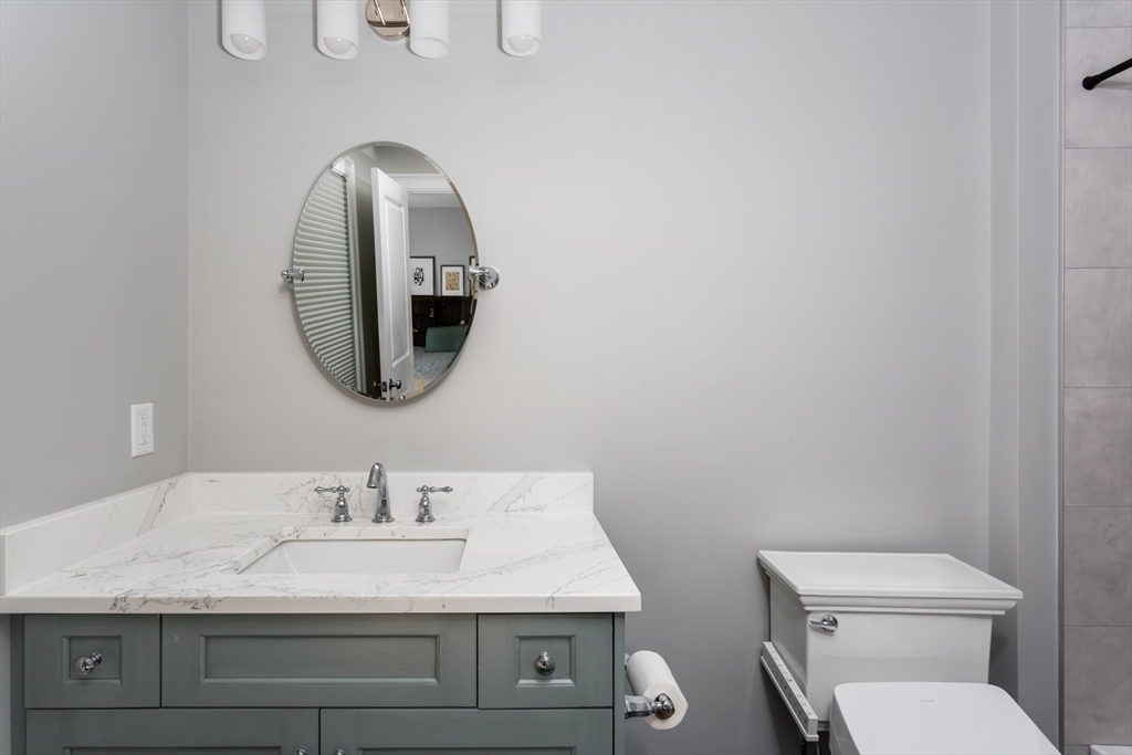 216 Oak Street Westwood, MA 02090 - Photo 35 of 37 a bathroom with a granite countertop toilet a sink and mirror