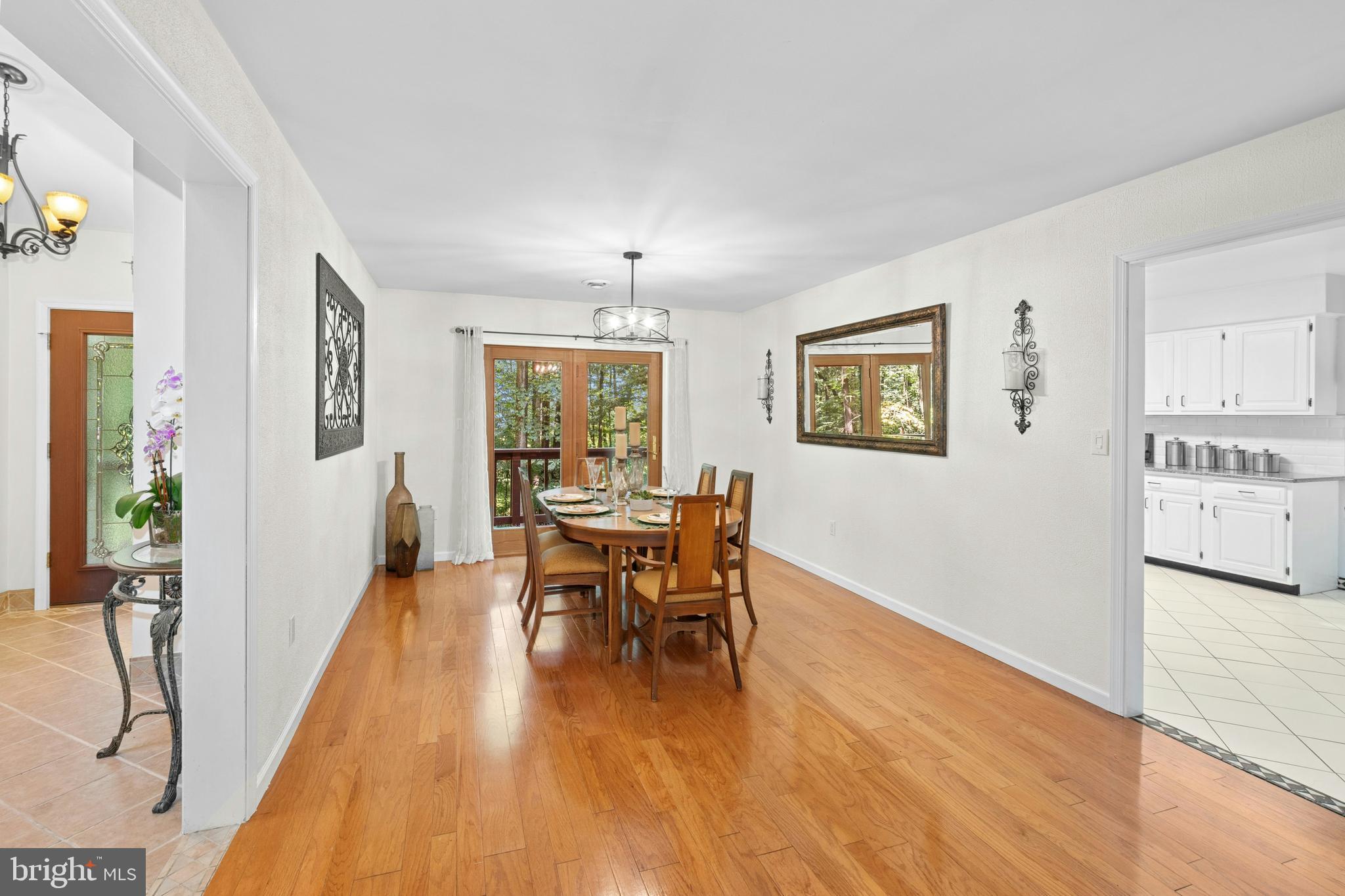 1715 Kumry Road Quakertown, PA 18951 - Photo 9 of 37 a dining room with wooden floor a chandelier a glass table and chairs