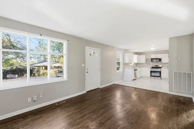 a view of a kitchen with wooden floor and a window