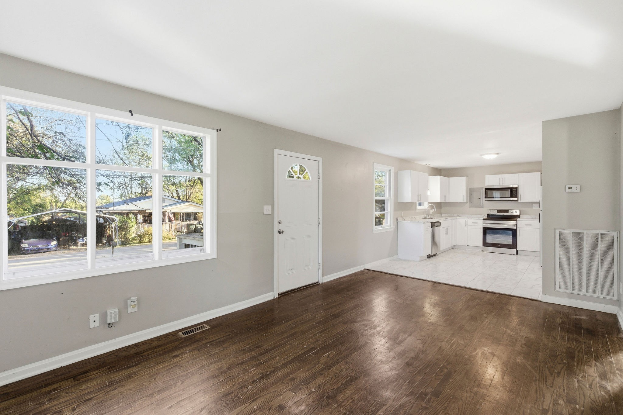 a view of a kitchen with wooden floor and a window