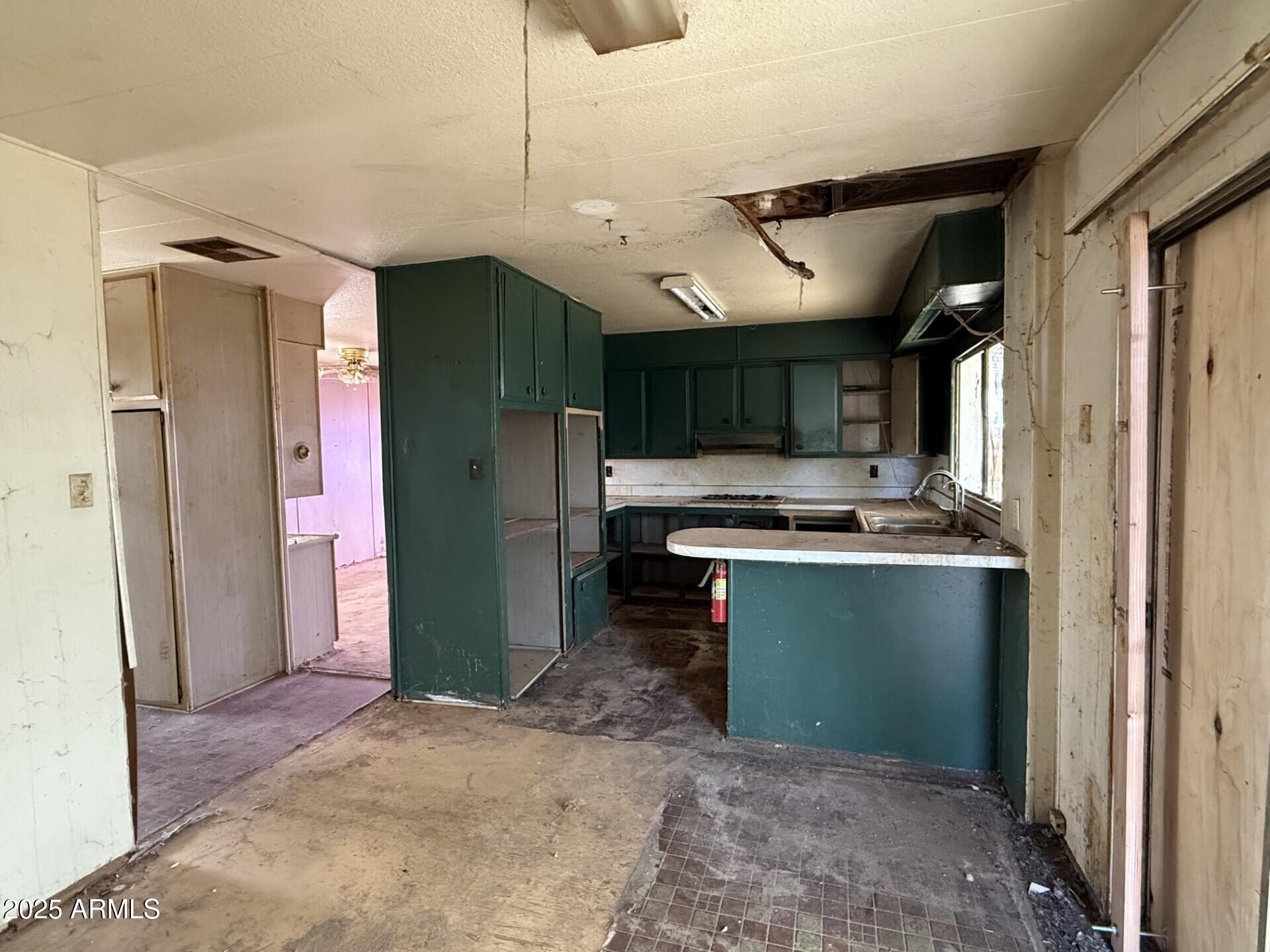 7122 North 68th Drive Glendale, AZ 85303 - Photo 3 of 6 a kitchen with stainless steel appliances kitchen island granite countertop a refrigerator and a sink