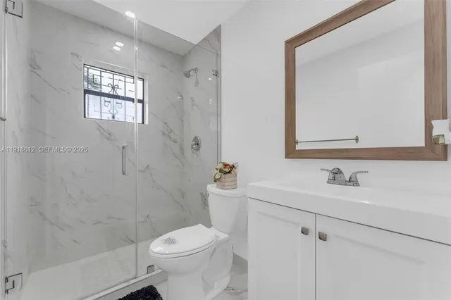 a white toilet sitting next to a bathroom sink