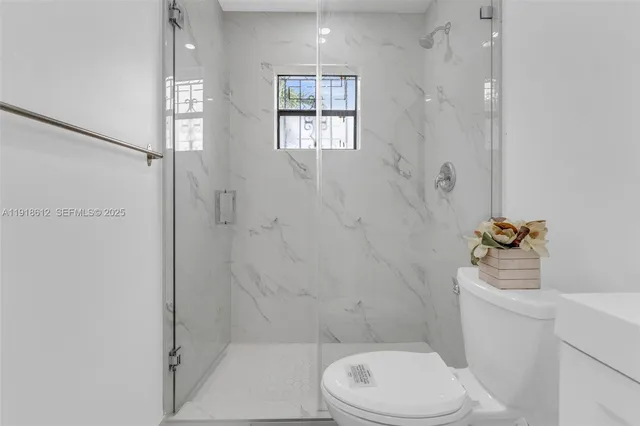 a white toilet sitting next to a bathroom sink and tub