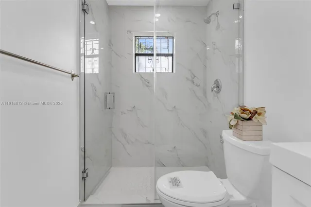 a white toilet sitting next to a bathroom sink and tub