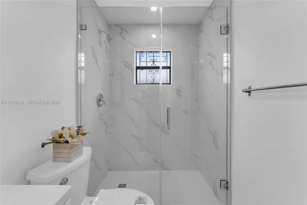 a bathroom with a toilet a sink and mirror