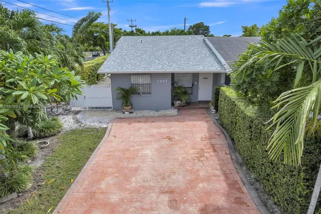 a aerial view of a house with a yard and potted plants