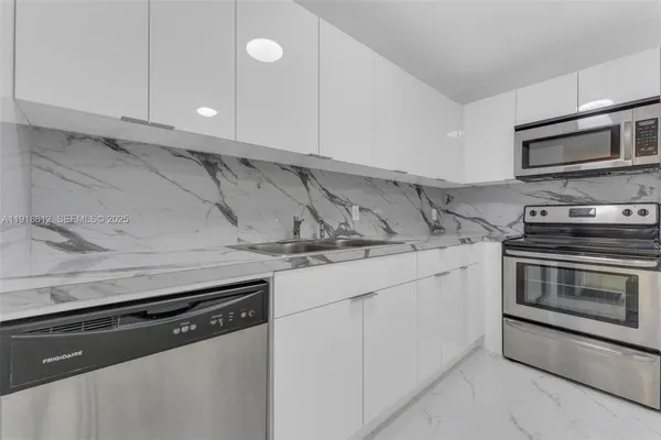 a kitchen with stainless steel appliances granite countertop a sink and a stove
