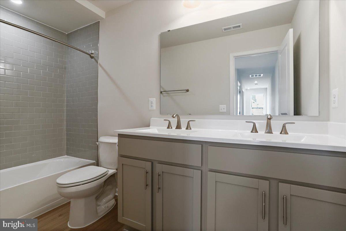 62 Peters Avenue Ranson, WV 25438 - Photo 11 of 31 a bathroom with a granite countertop sink a toilet and a mirror