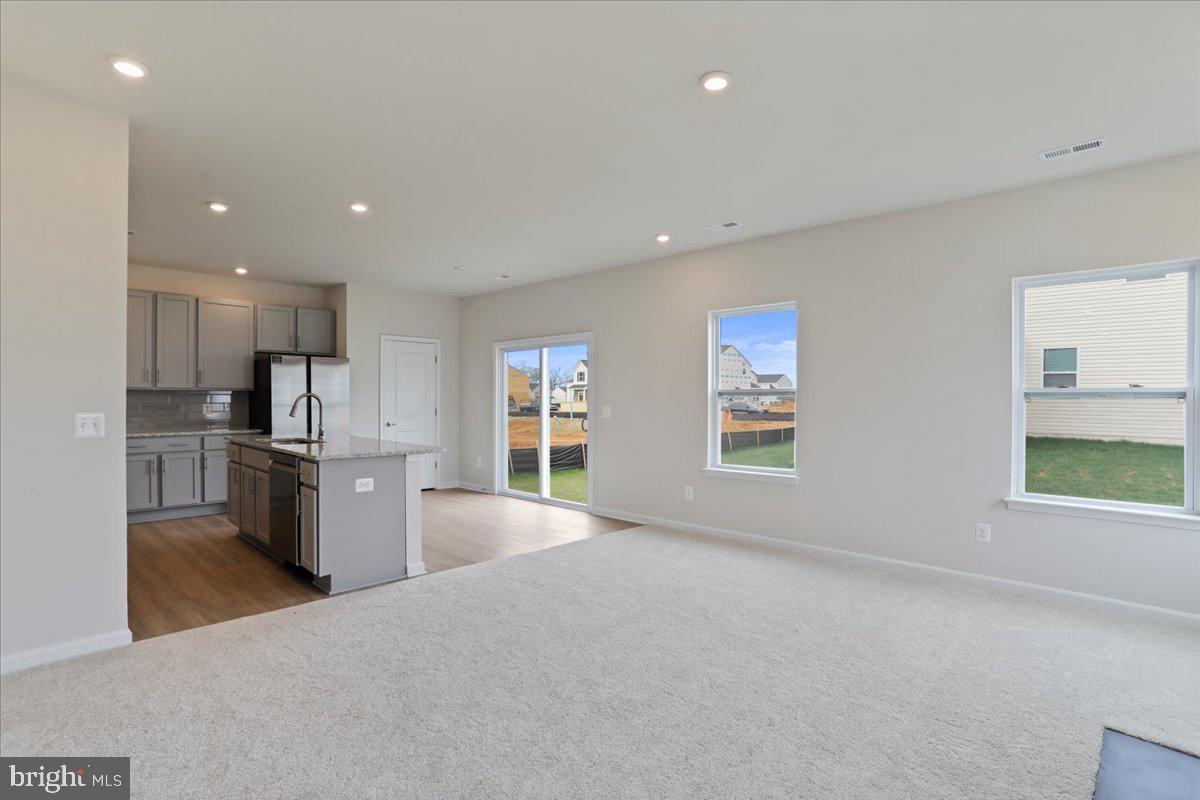 62 Peters Avenue Ranson, WV 25438 - Photo 13 of 31 a view of kitchen with stainless steel appliances kitchen island wooden floor and window