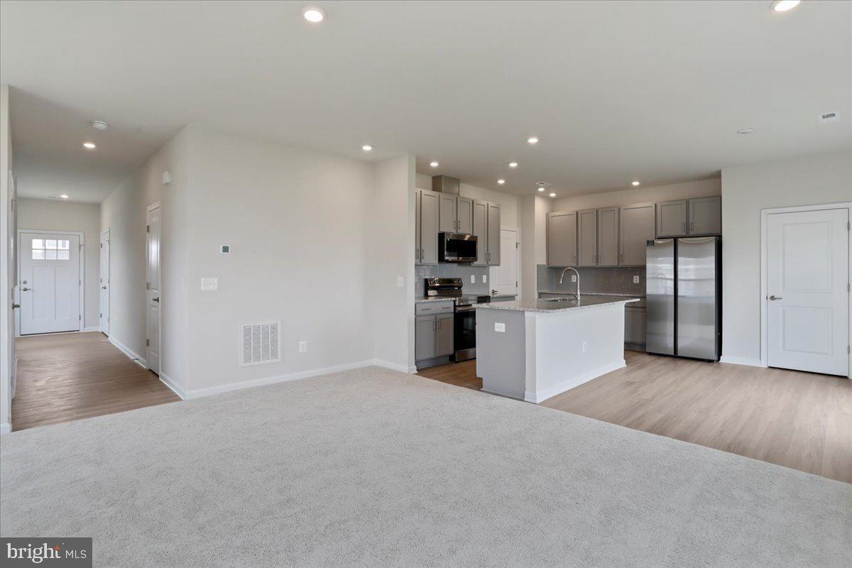 62 Peters Avenue Ranson, WV 25438 - Photo 14 of 31 a view of a kitchen with a sink and dishwasher a refrigerator with wooden floor