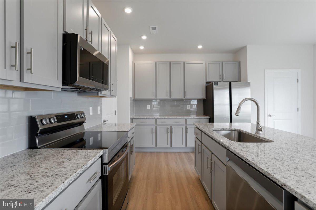 62 Peters Avenue Ranson, WV 25438 - Photo 5 of 31 a kitchen with stainless steel appliances granite countertop a sink stove microwave and refrigerator