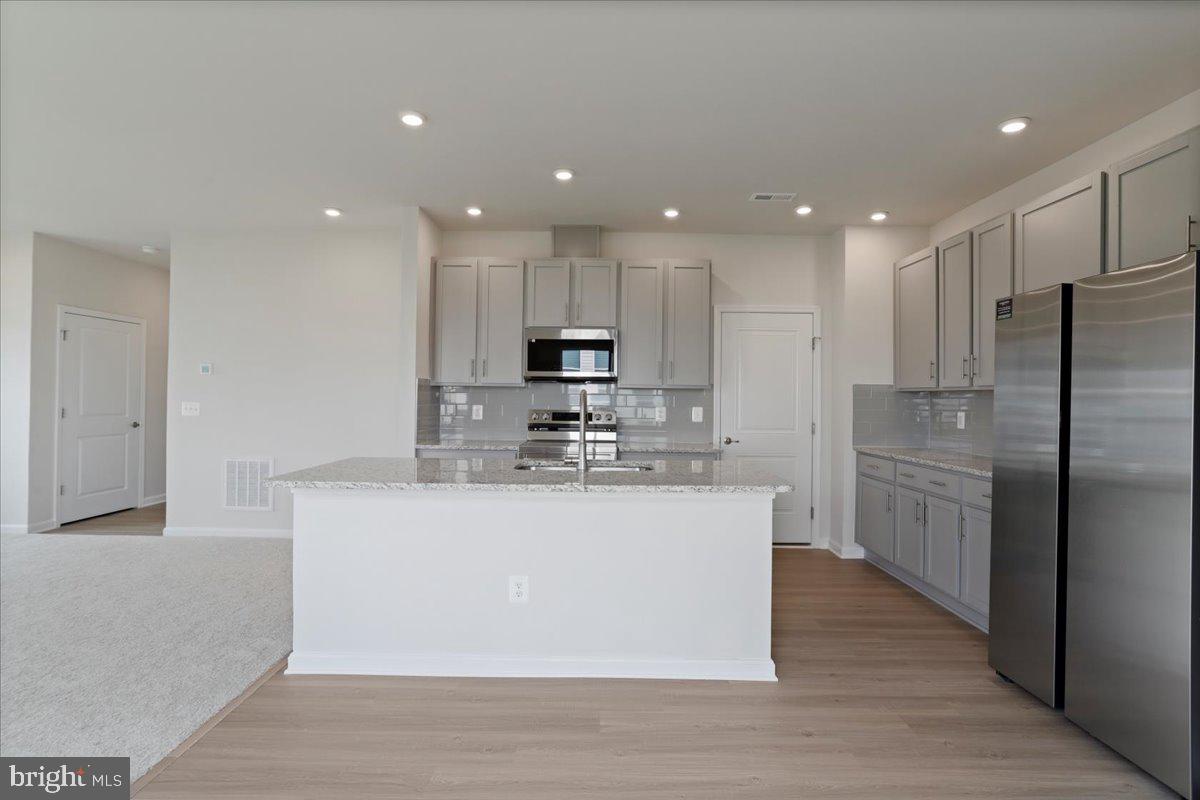 62 Peters Avenue Ranson, WV 25438 - Photo 6 of 31 a kitchen with stainless steel appliances granite countertop a sink a refrigerator and a stove