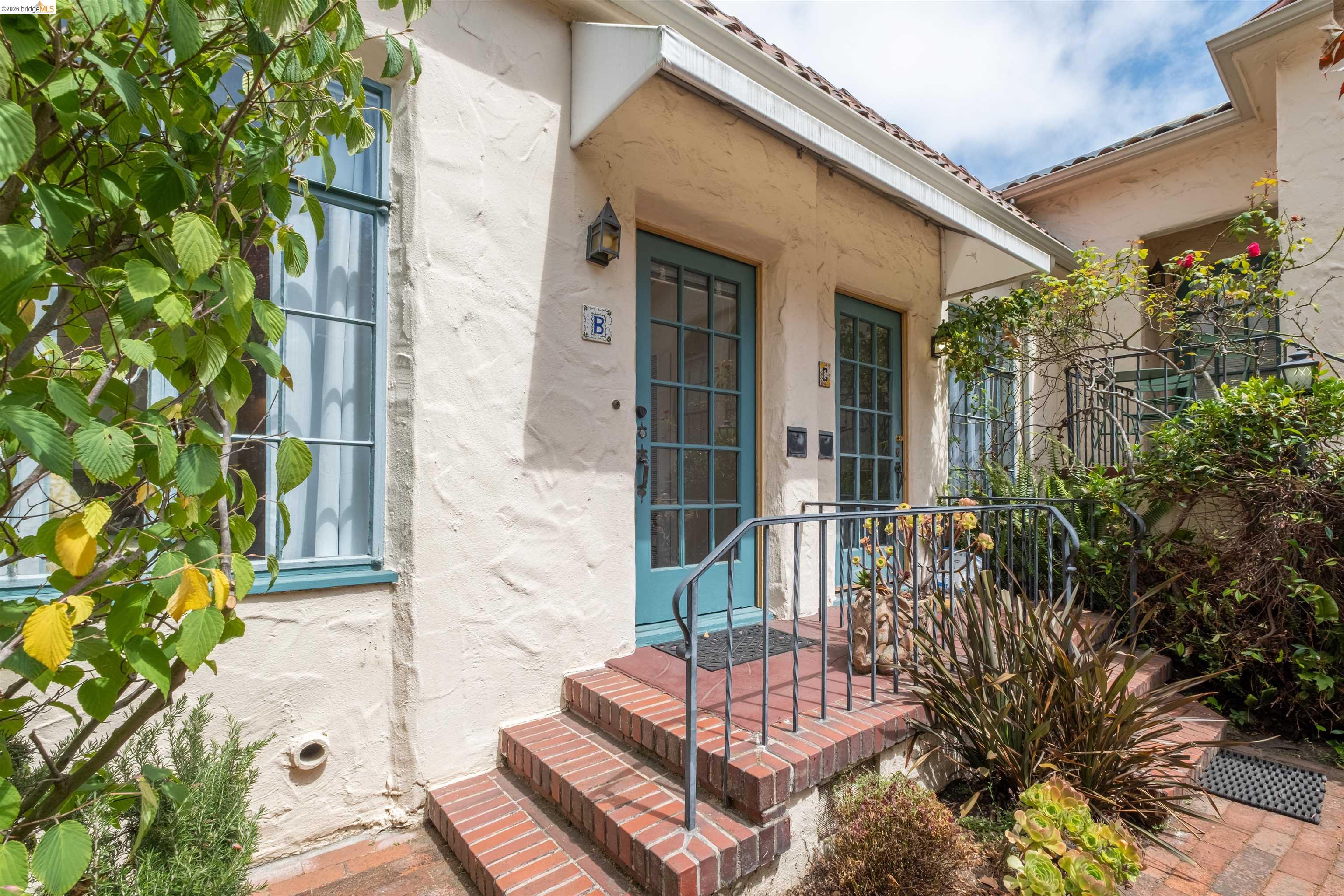 2444 Virginia Street, Unit B Berkeley, CA 94709 - Photo 8 of 39 Entryway featuring a stucco exterior, brick steps, and teal-framed glass paneled doors