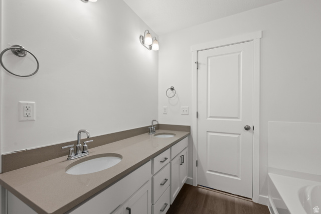 1554 Pheasant Road Eagle Mountain, UT 84005 - Photo 27 of 29 Bathroom featuring double vanity, a bath, and dark wood finished floors