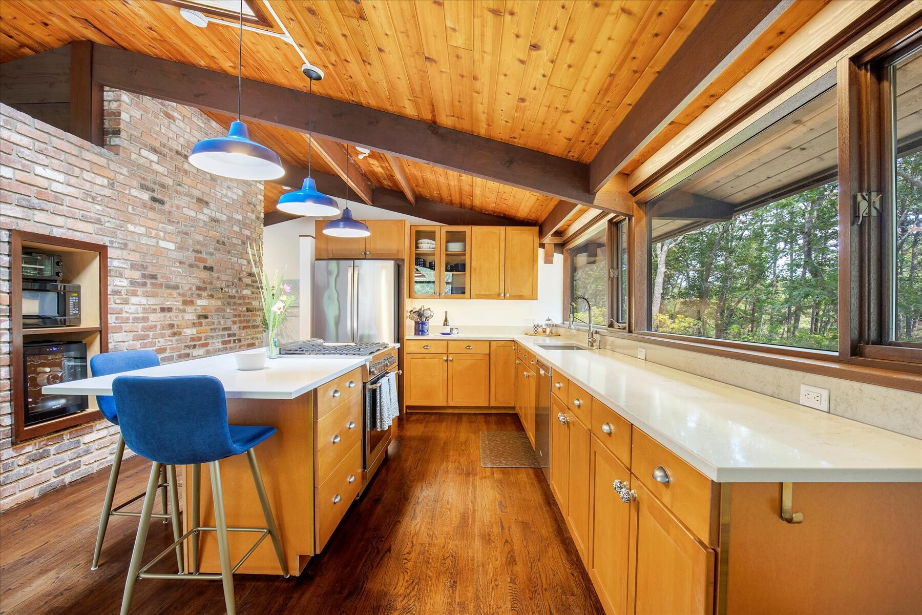 80 Woodlot Road Wellfleet, MA 02667 - Photo 19 of 67 a large kitchen with wooden floor and stainless steel appliances