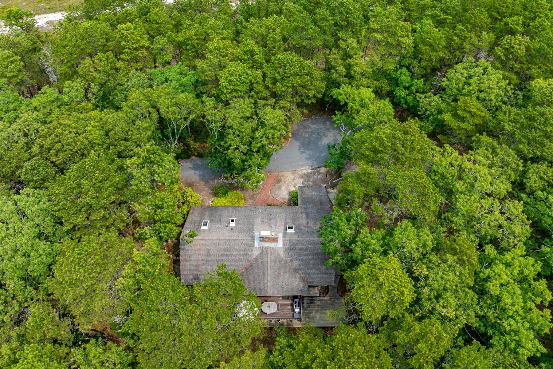 80 Woodlot Road Wellfleet, MA 02667 - Photo 57 of 67 an aerial view of a house with a yard and trees all around