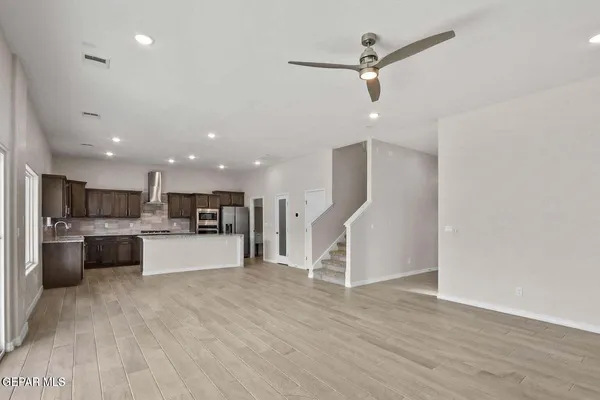 a kitchen with stainless steel appliances granite countertop a sink refrigerator and cabinets