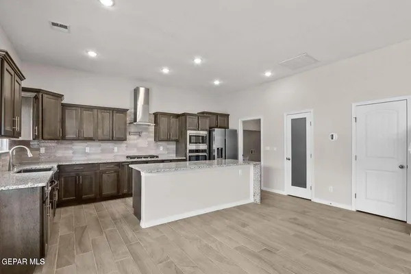 an empty room with wooden floor and entryway