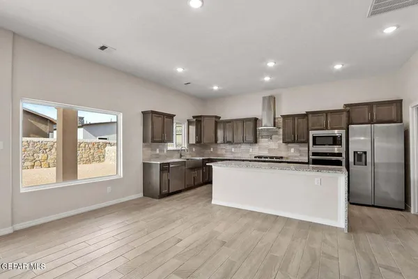 a kitchen with stainless steel appliances granite countertop a sink stove and refrigerator