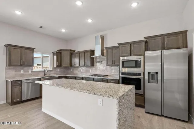 a large kitchen with stainless steel appliances and a sink