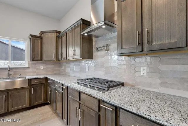 a large kitchen with granite countertop a large counter top stainless steel appliances and cabinets