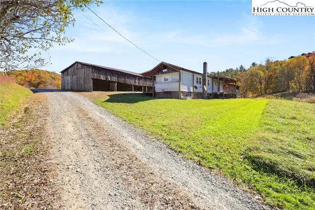a house view with a big yard plants and large trees