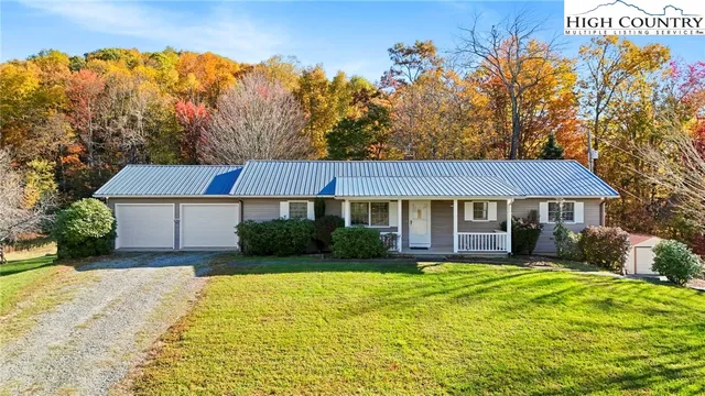 a view of a house with yard and tree s