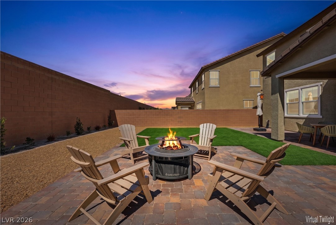 3705 Alla Rocca Avenue Henderson, NV 89044 - Photo 33 of 50 This inviting patio features a fire pit, perfect for evening gatherings under a beautiful sunset.