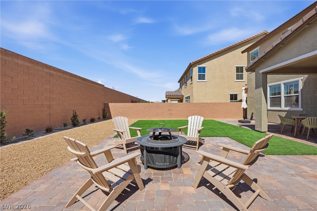 3705 Alla Rocca Avenue Henderson, NV 89044 - Photo 34 of 50 This private yard features a charming patio, fire pit, and lush artificial turf.