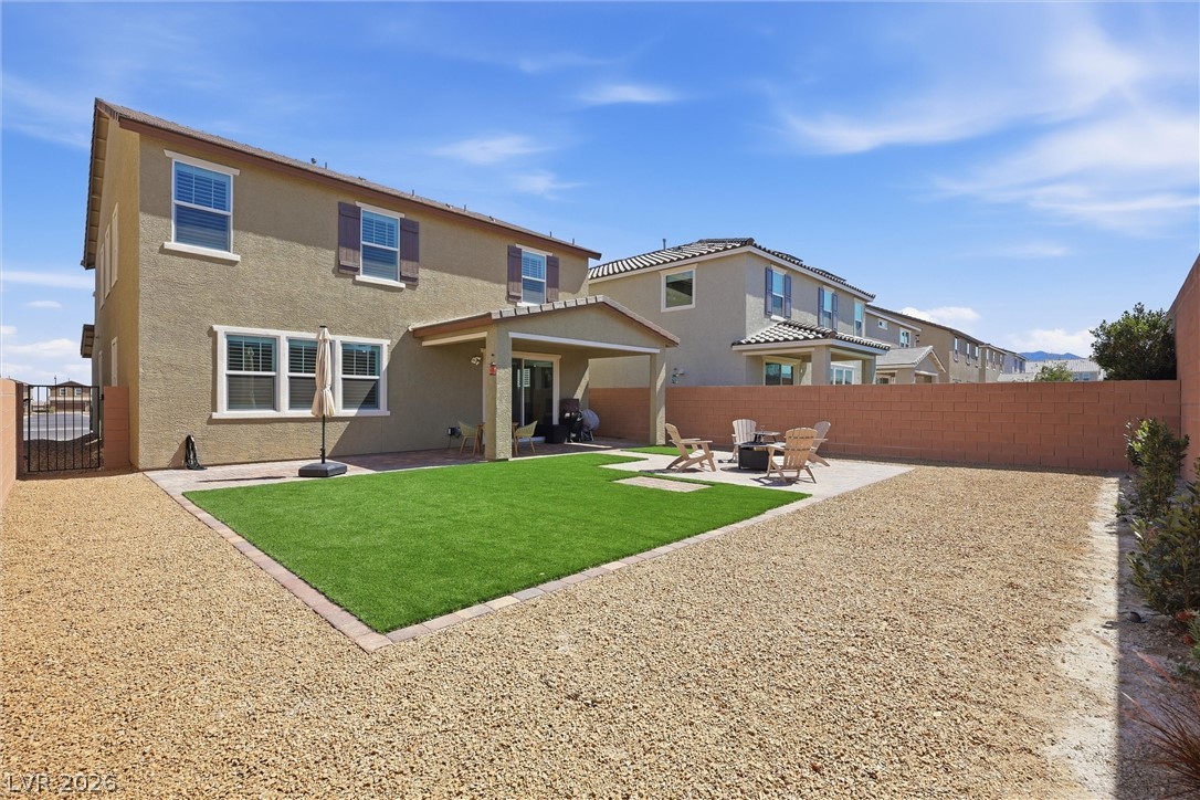 3705 Alla Rocca Avenue Henderson, NV 89044 - Photo 37 of 50 This spacious backyard offers both a covered patio and an open-air fire pit area, perfect for entertaining.