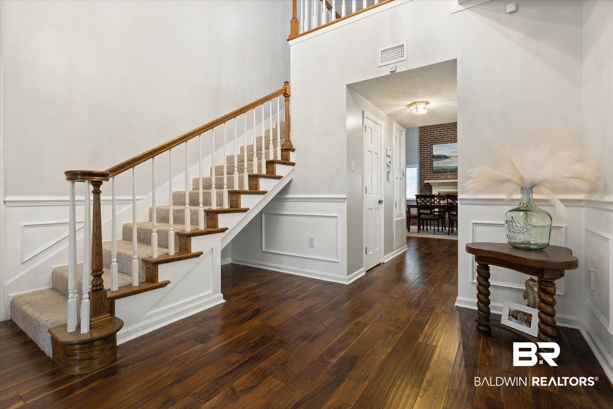 2300 Radcliff Road Saraland, AL 36571 - Photo 4 of 56 Stairs featuring a decorative wall, hardwood / wood-style floors, wainscoting, and a high ceiling