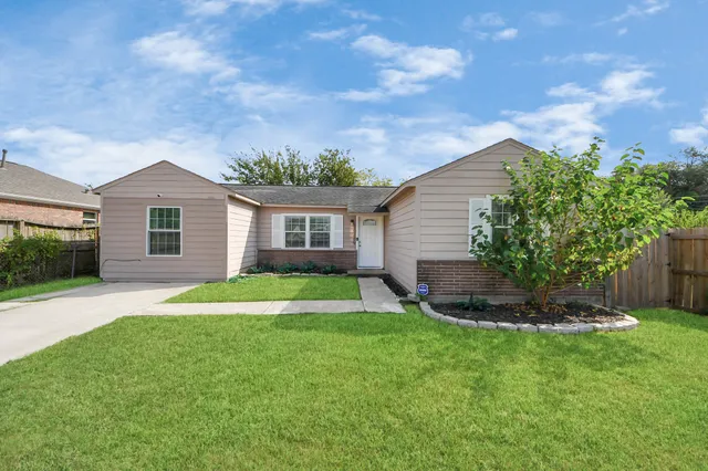 a backyard of a house with plants and barbeque oven