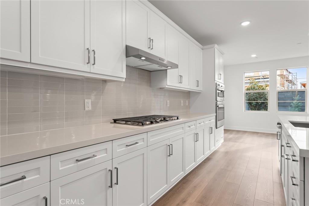 5208 Solace Drive Rancho Mission Viejo, CA 92694 - Photo 10 of 27 a kitchen with granite countertop white cabinets and a stove
