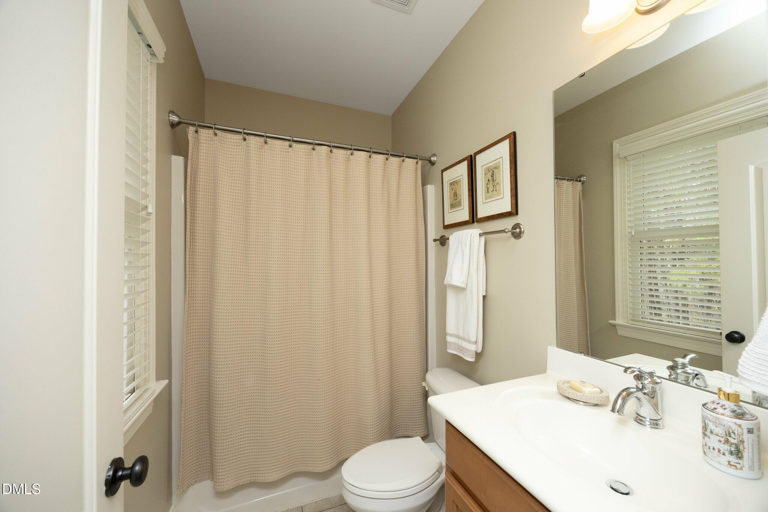 2705 Peachleaf Street Raleigh, NC 27614 - Photo 24 of 52 a bathroom with a sink a toilet and shower curtain