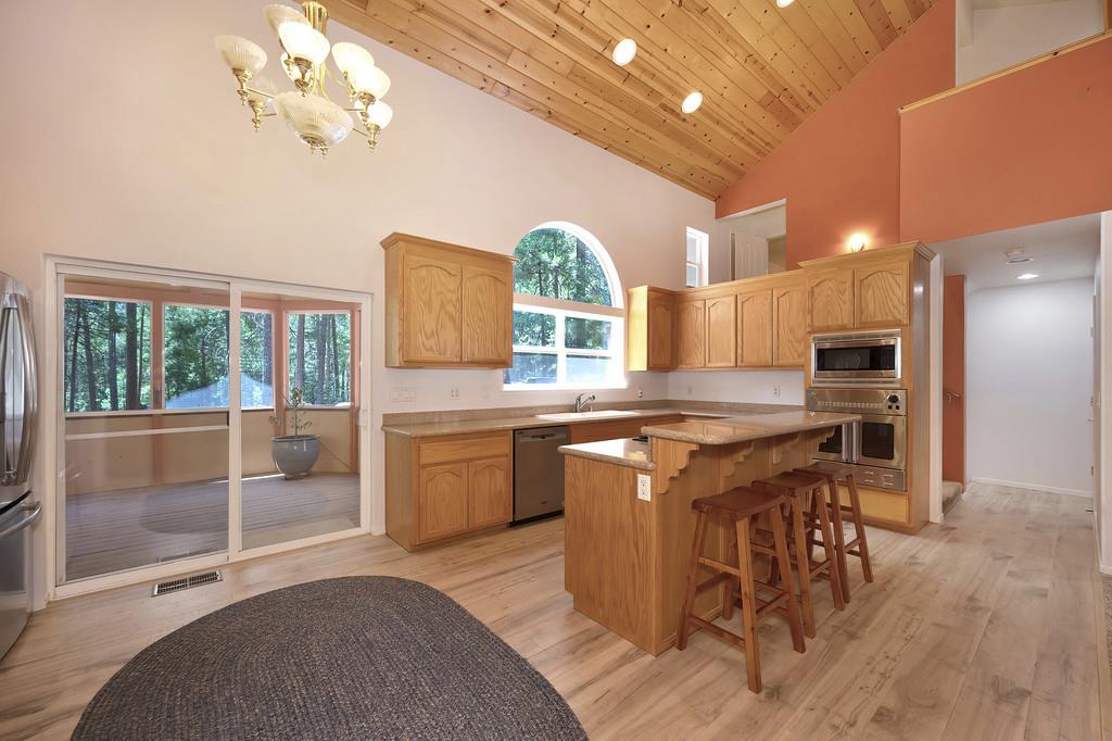 1861 Rubicon Road Georgetown, CA 95634 - Photo 18 of 68 a kitchen with stainless steel appliances granite countertop a stove a refrigerator a sink a dining table and chairs with wooden floor