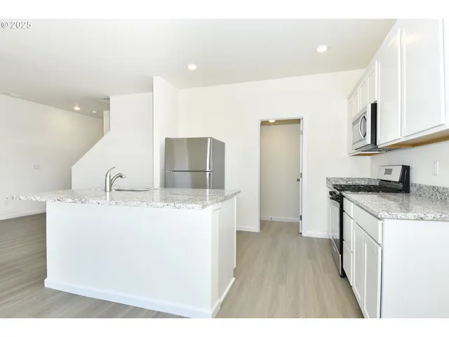 a kitchen with sink a refrigerator and wooden cabinets