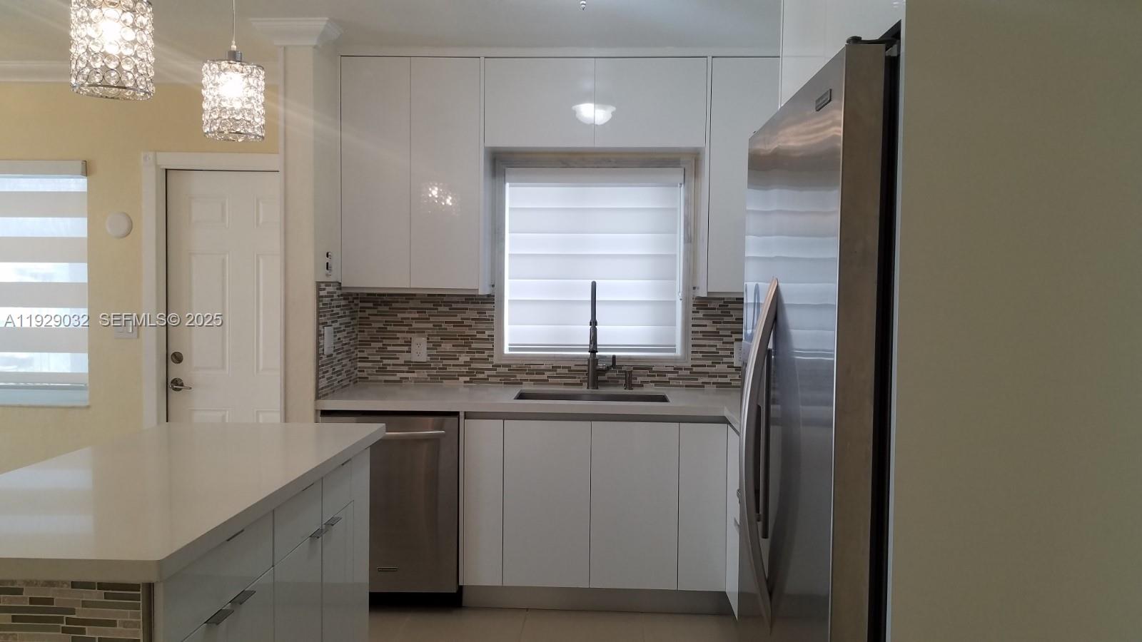 1071 West 66th Street Hialeah, FL 33012 - Photo 7 of 17 a kitchen with stainless steel appliances granite countertop a sink and a refrigerator