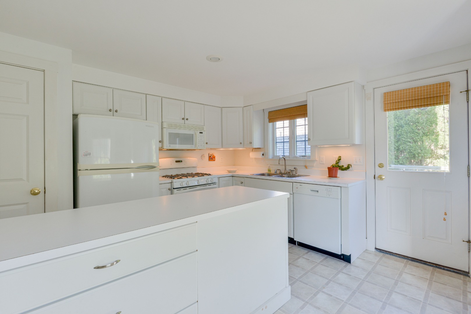 12 Appleton Road Nantucket, MA 02554 - Photo 10 of 24 a kitchen with white cabinets and white appliances