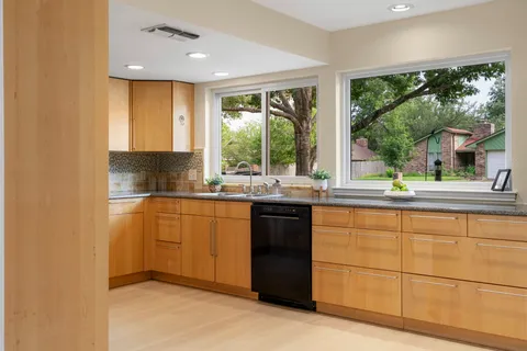 a kitchen with stainless steel appliances granite countertop a sink and a stove