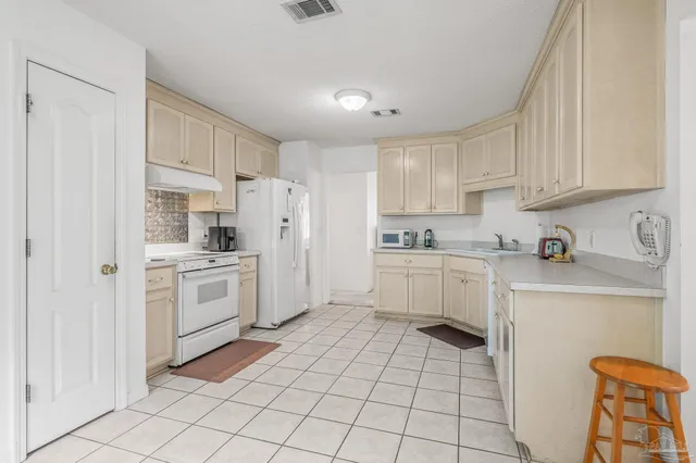 a kitchen with white cabinets and white appliances