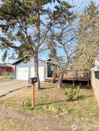 a front view of a house with a yard outdoor seating and covered with trees