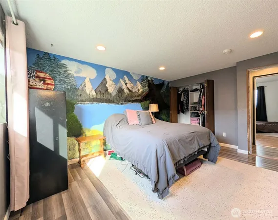 a bed sitting in a spacious bedroom next to a window