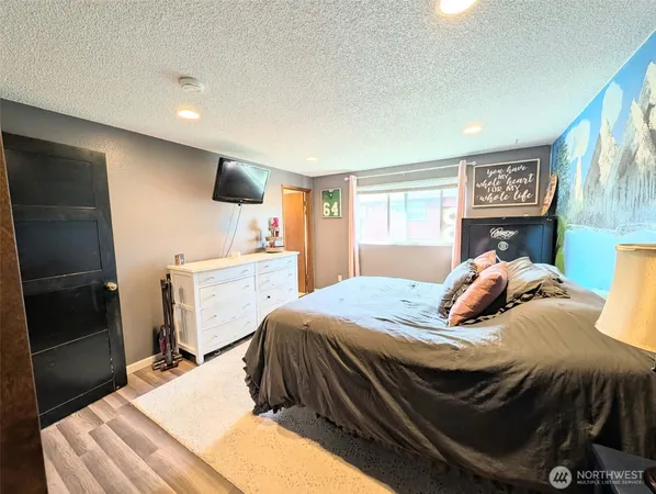 a bedroom with a bed and a refrigerator