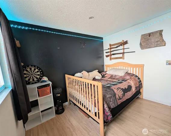 a bedroom with a bed and wooden floor