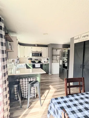 a kitchen with stainless steel appliances kitchen island granite countertop a refrigerator and cabinets