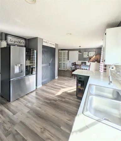 a room with stainless steel appliances kitchen island a stove a refrigerator and cabinets