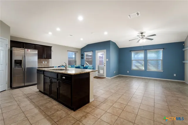 a kitchen with stainless steel appliances granite countertop a refrigerator and a sink