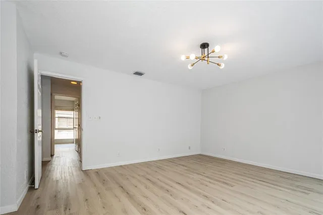 a view of a room with wooden floor and a ceiling fan