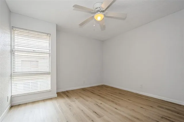 an empty room with a window and wooden floor