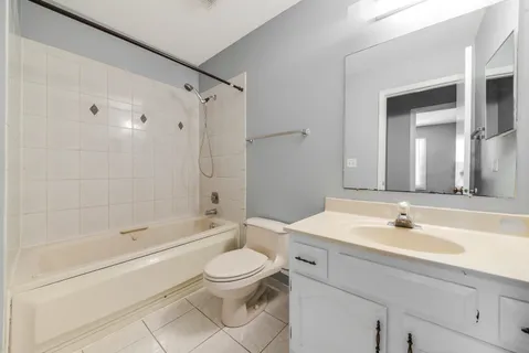 a bathroom with a bathtub shower sink vanity and toilet